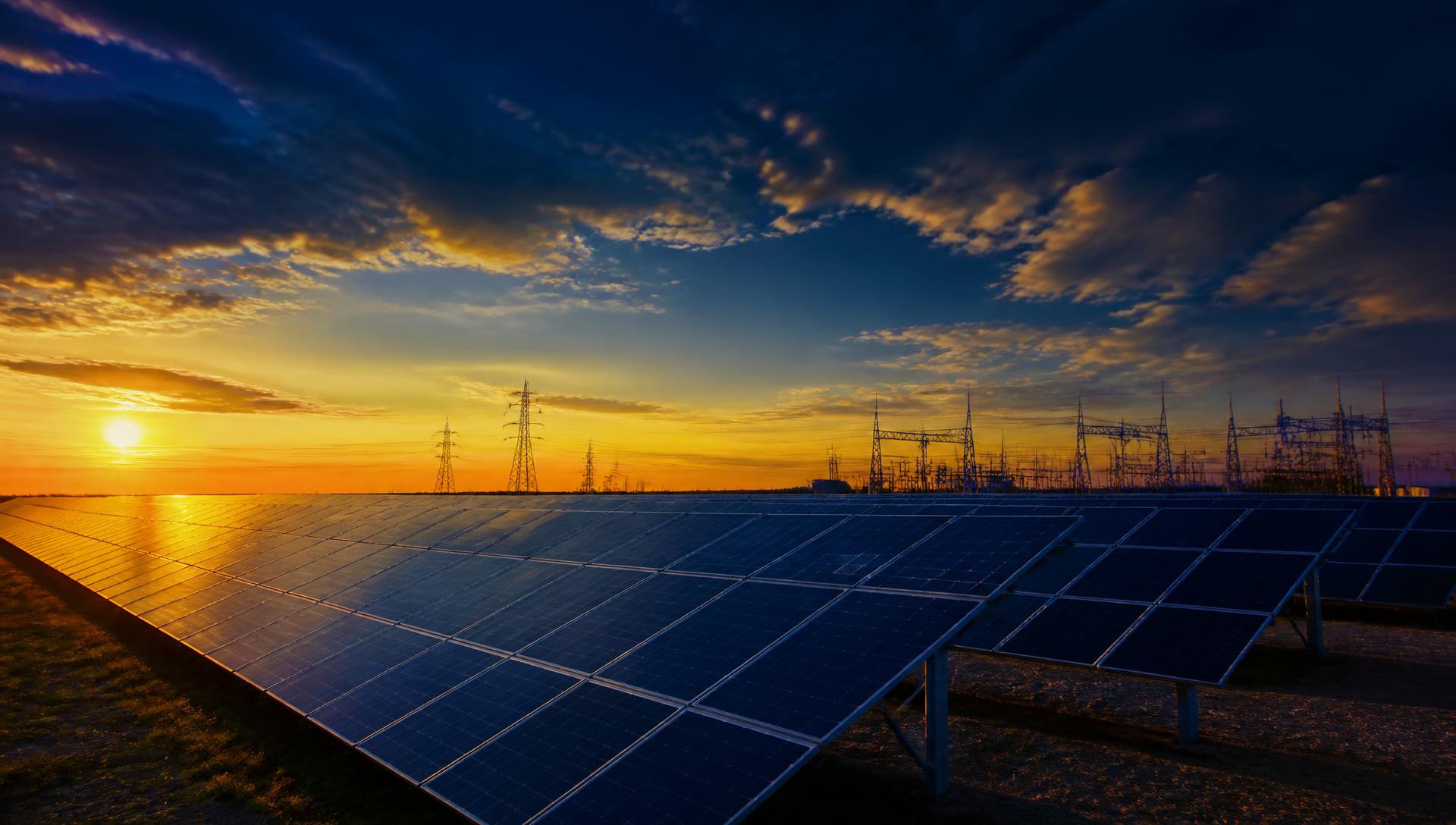 Large-scale solar installation with electrical transmission infrastructure at dusk